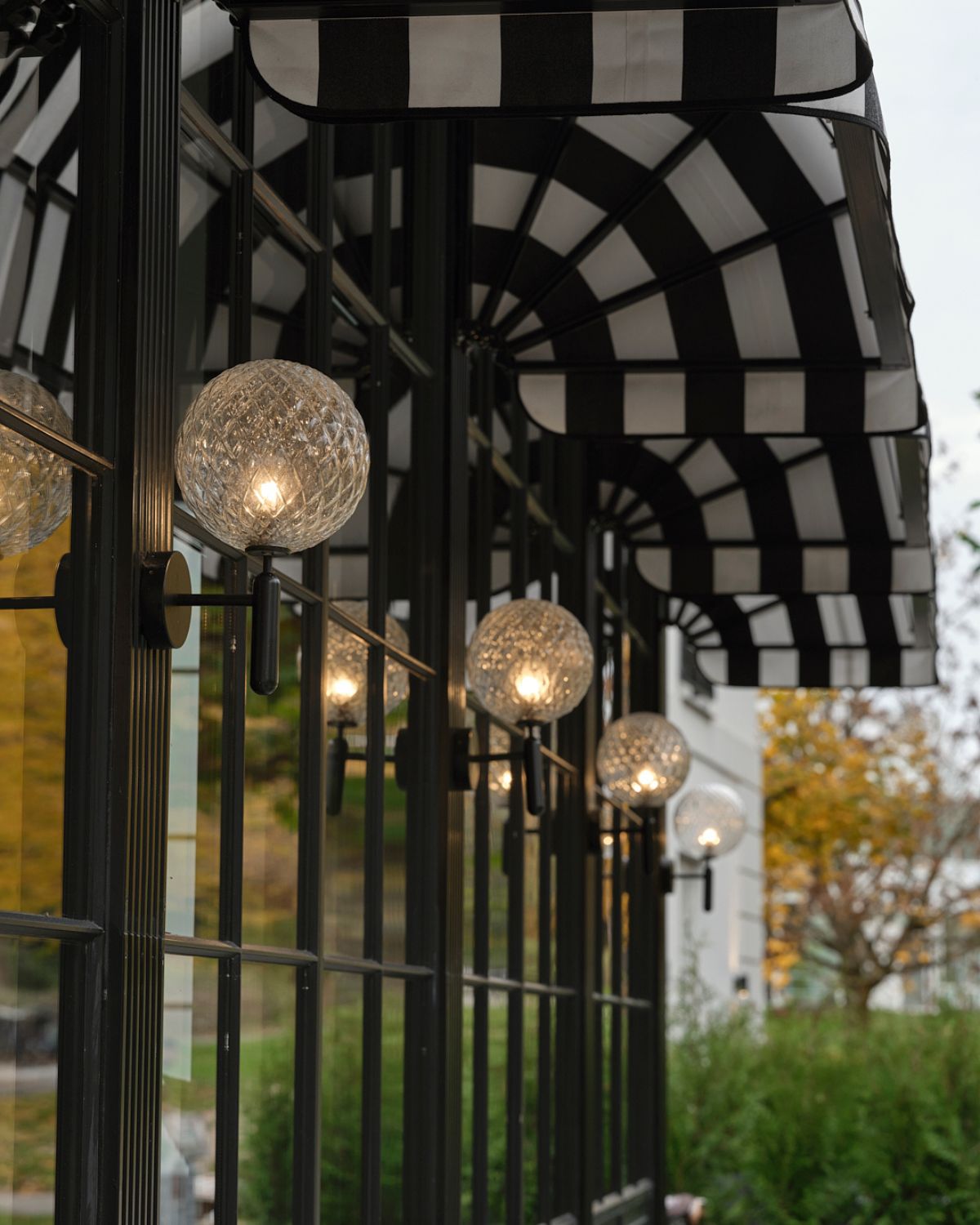 Decorative outdoor gazebo with black and white checkered roof and hanging lights.